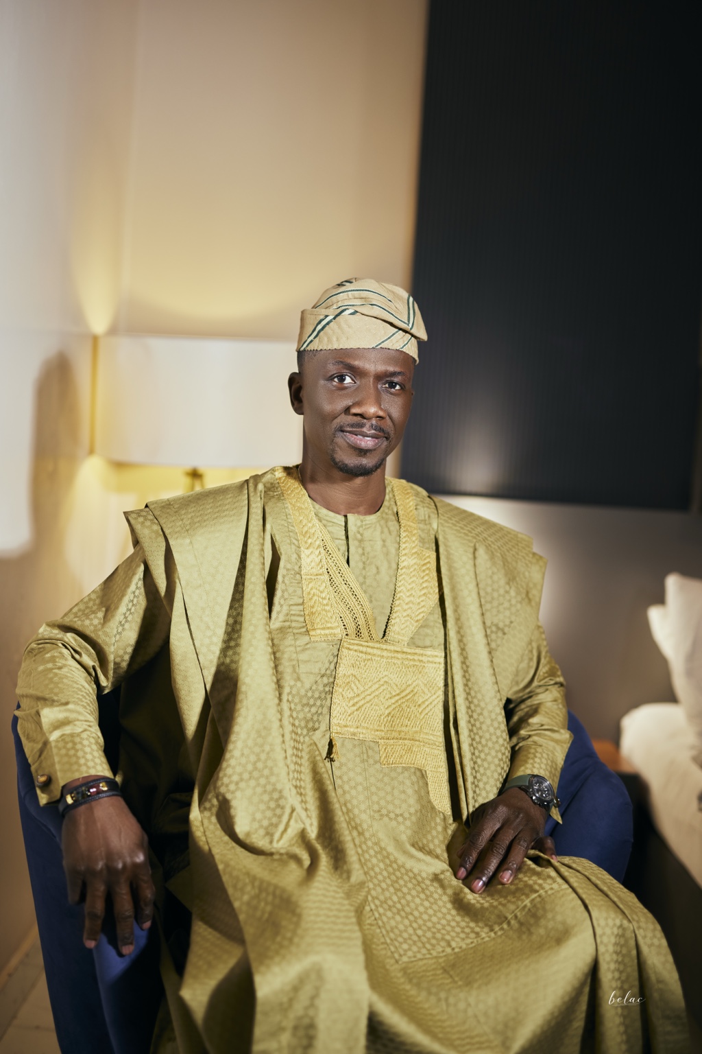 Kassim Alli-Balogun smiling in gold agbada and a traditional cap